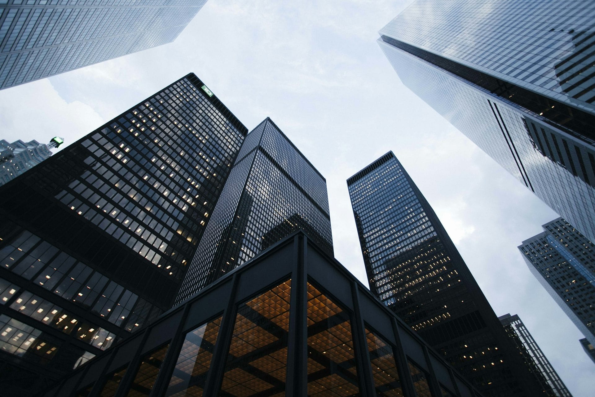 Modern glass skyscrapers rising toward a cloudy sky